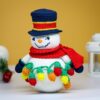 crochet snowman with festive christmas light bulbs