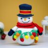 crochet snowman with festive christmas light bulbs